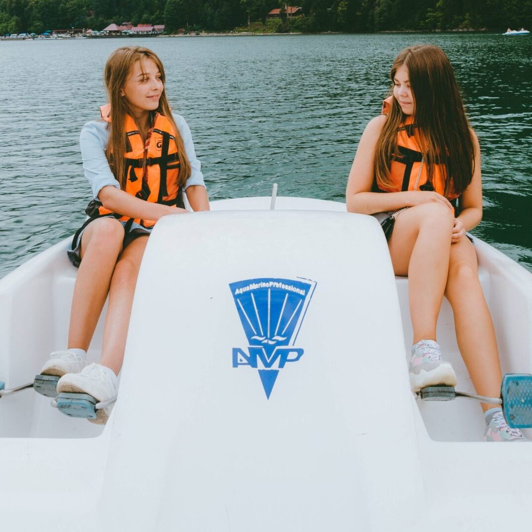 A picture of two young girls riding a paddleboat